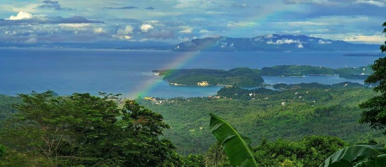 Panoramic view from Sunrise Residences with rainbow over Puerto Galera bay